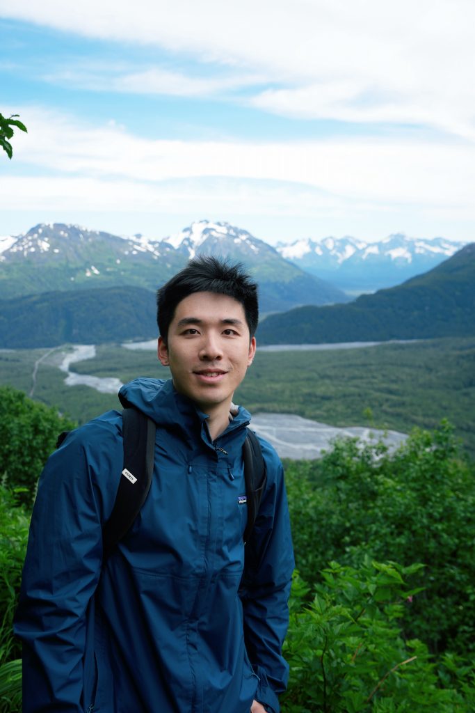 Jerry Jiang in front of a braided glacial river valley in Alaska